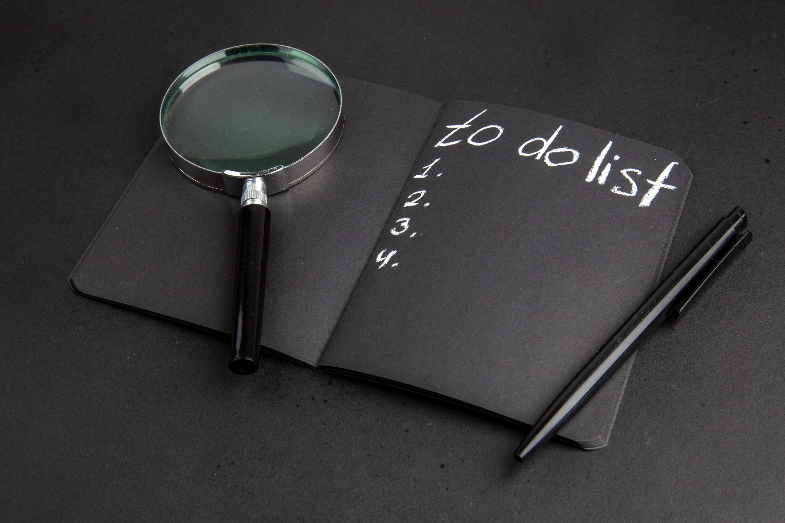 bottom-view-list-written-black-notepad-lupa-pen-black-table